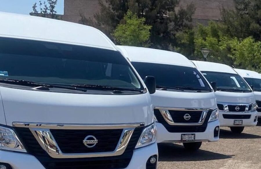Camionetas Urvan blancas de 13 lugares de zertravel formadas para traslados de personal y al aeropuerto