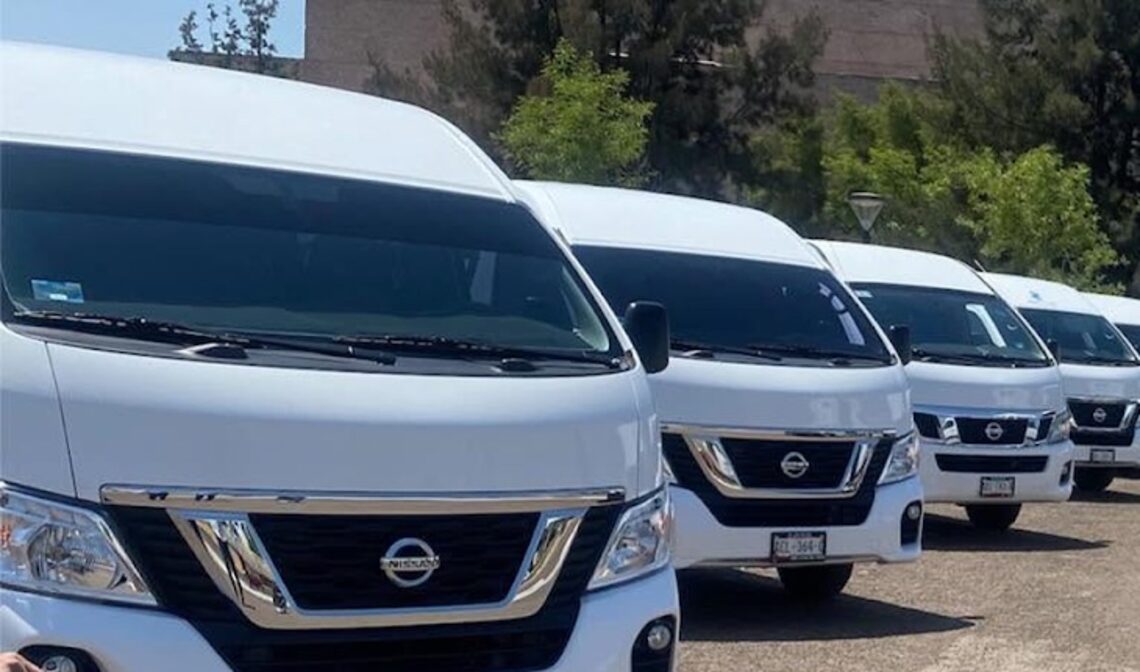 Camionetas Urvan Nissan blancas de 13 lugares de zertravel formadas para traslados al aeropuerto